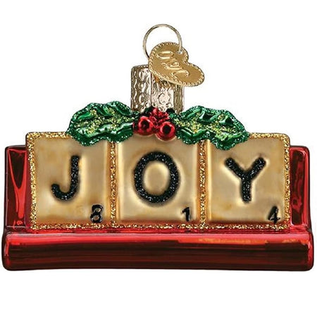 Glass hanging ornament shaped like a scrabble game with the red tile holder and the letters JOY with holly accent.