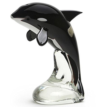 Glass Figurine shaped like an Orca Whale in black and white and the whales is jumping on a wave made of clear glass