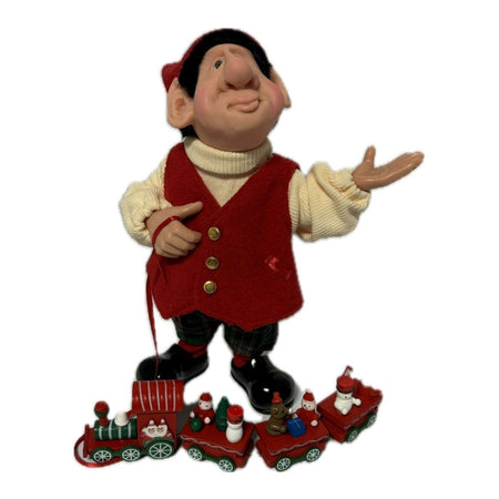 moochie the elf figurine with a toy train on a ribbon.
