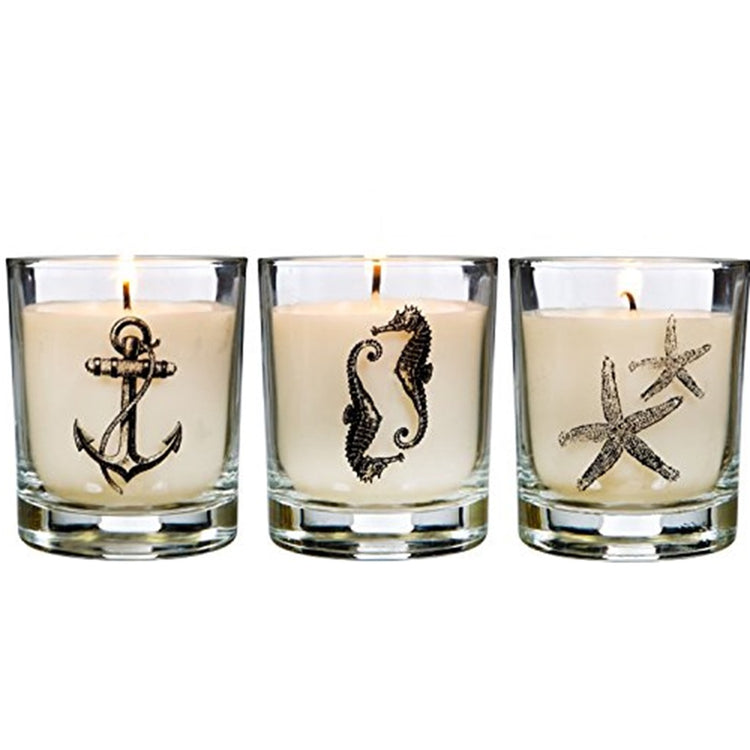 3 candle votives in clear glass with cream color candles. Glass is designed, 1 each: nautical anchor, 2 seahorses and 2 starfish.