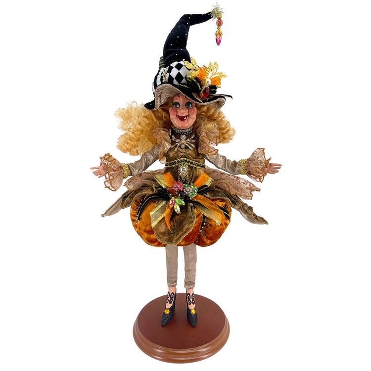 Halloween-themed figurine in witch costume and pumpkin, on a white background