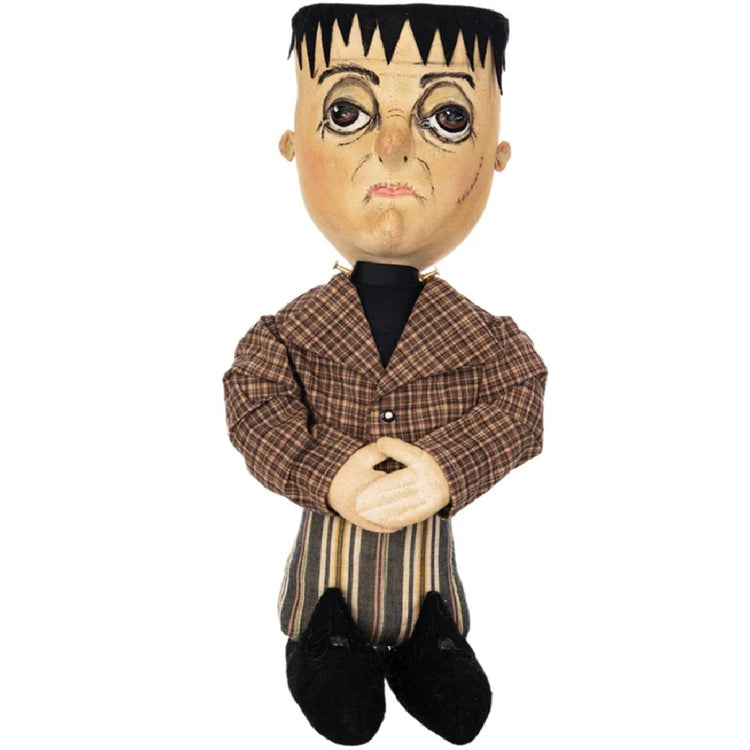 Figurine with resembelence of Frankenstsin with block head. brown plaid and striped suit, black boots.