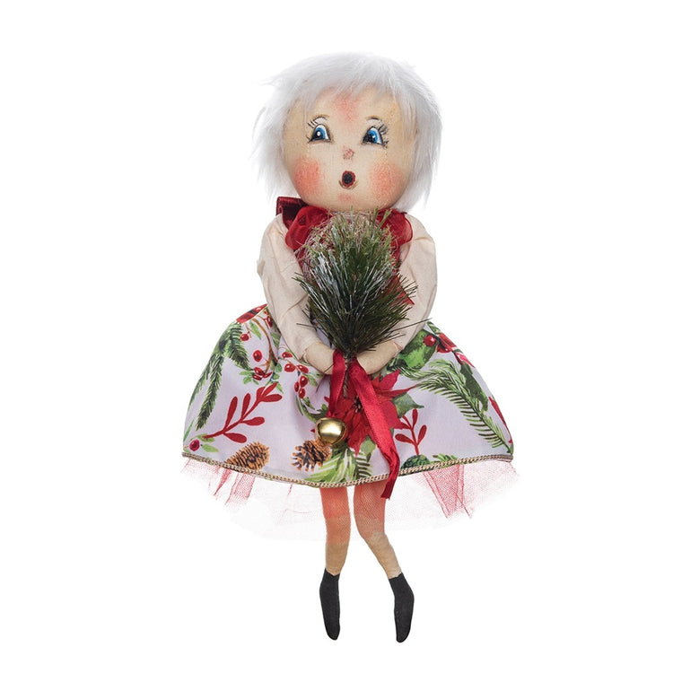 Doll figure with white hair wearing a dress with greenery and holly.  She carries a pine swag and a jingle ball on a red ribbon.
