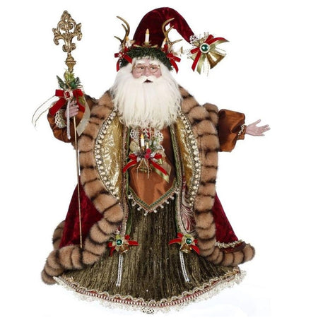 Santa in a long green and gold robe and a red velvet, fur trimmed coat, Holding a golden staff and his hat has antlers and candles on it.