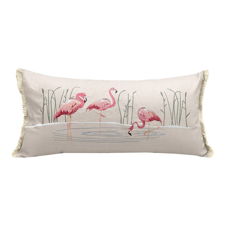 Tan pillow with embroidered flamingos in water with water plants.