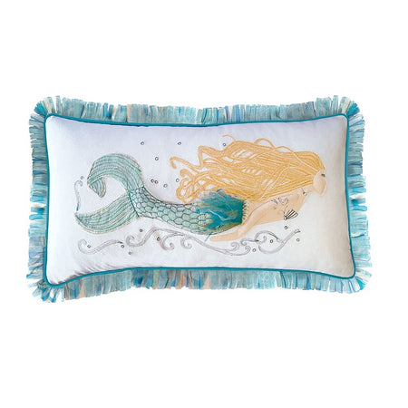 White pillow with blonde mermaid with a blue tail & blue fringe on the perimeter.