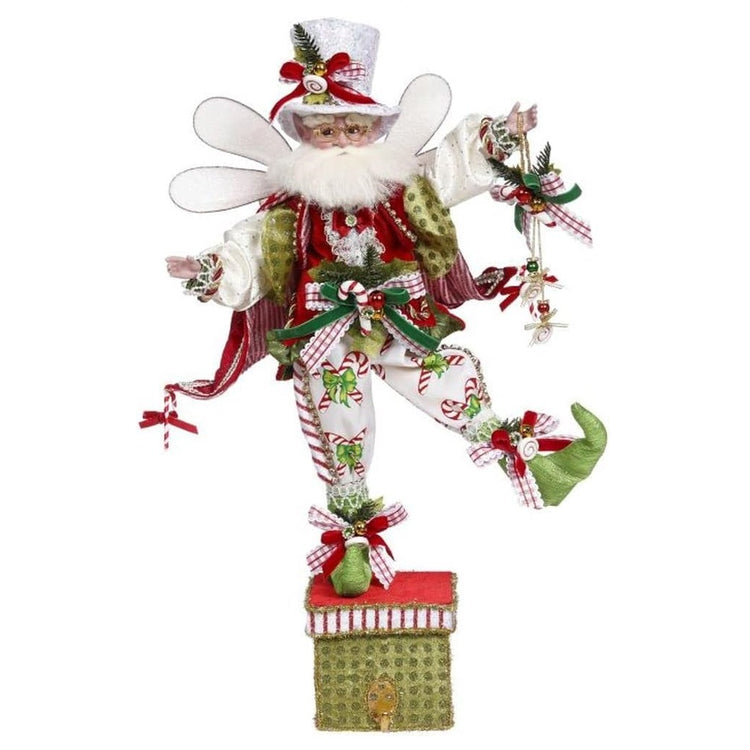 White bearded fairy standing on a stocking holder box.