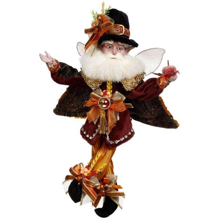 White bearded fairy with autumn colored outfit & hat, holding a pumpkin.