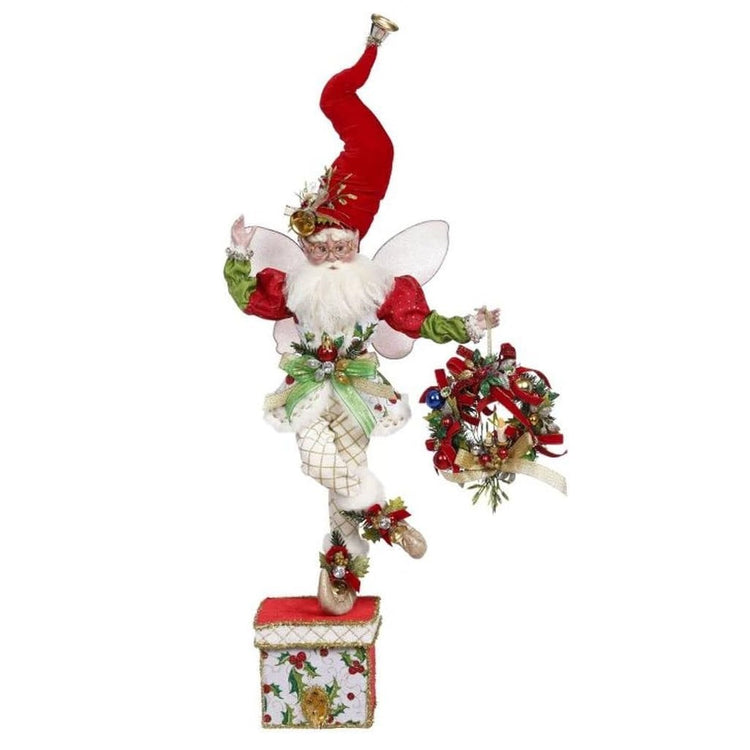 White bearded fairy, carrying a wreath on a stocking holder box.