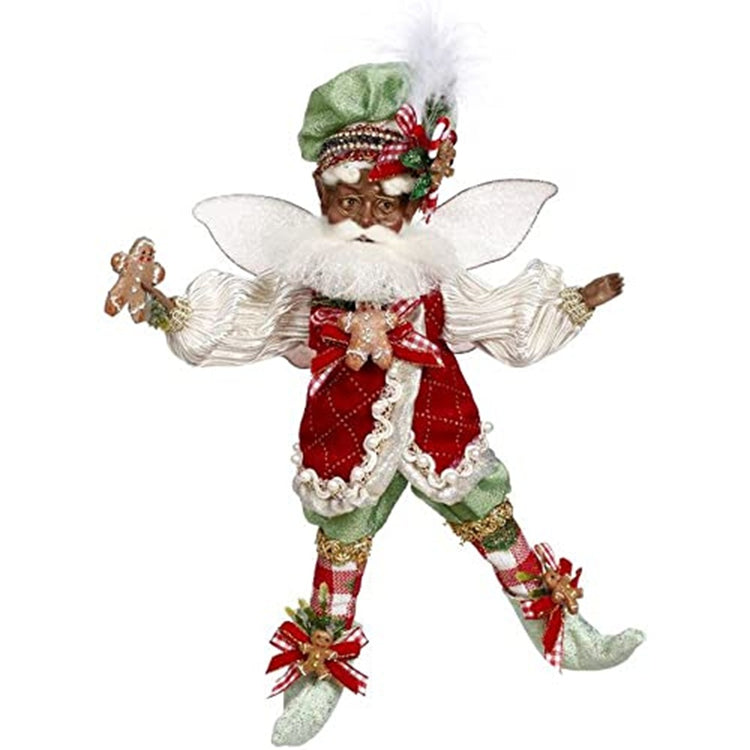 African American fairy figure in green shorts iwth matching booties and hat.  Red vest over white shirt.  He holds a gingebread cookie in his hands.
