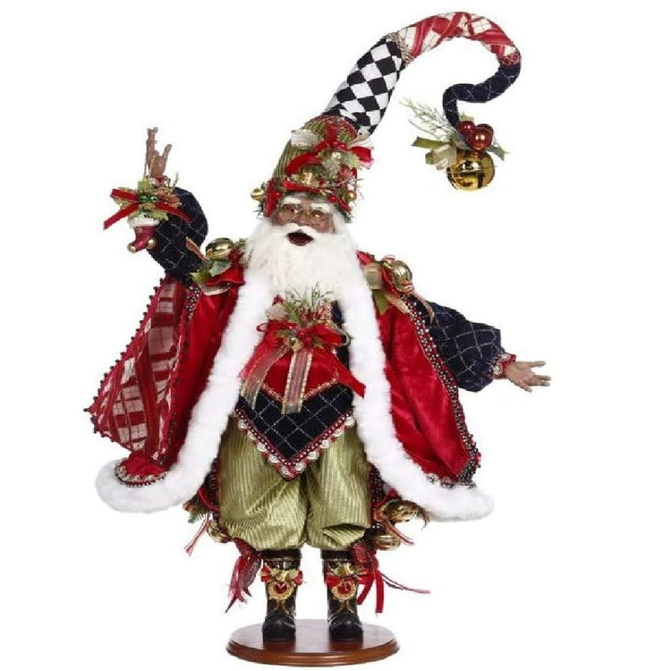 African American Santa figurine wearing green pants, a black shirt with red jacket or cape, and a black and white stocking cap. He's holding a small stocking ornament.