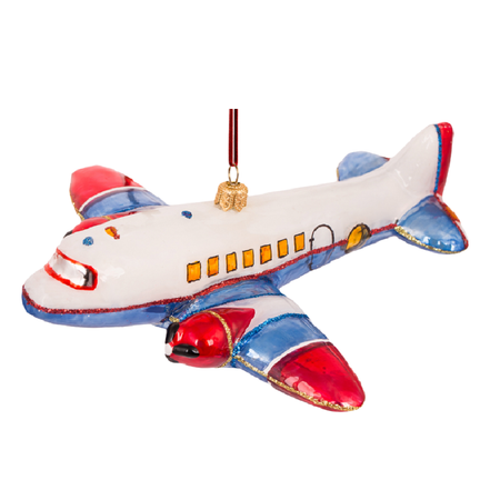 A decorative hanging airplane ornament with a white body, red nose and wingtips, blue wings and tail, small yellow window details, and a gold hanging loop.