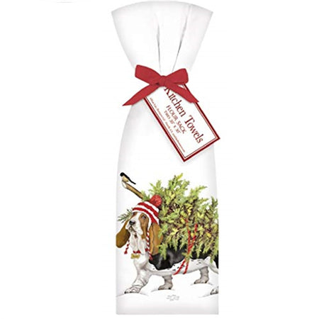 Shows a folded kitchen towel with a red fibbon.  The design is a basset hound carrying a christmas tree on his back with a chickadee sitting on the tree trunk.