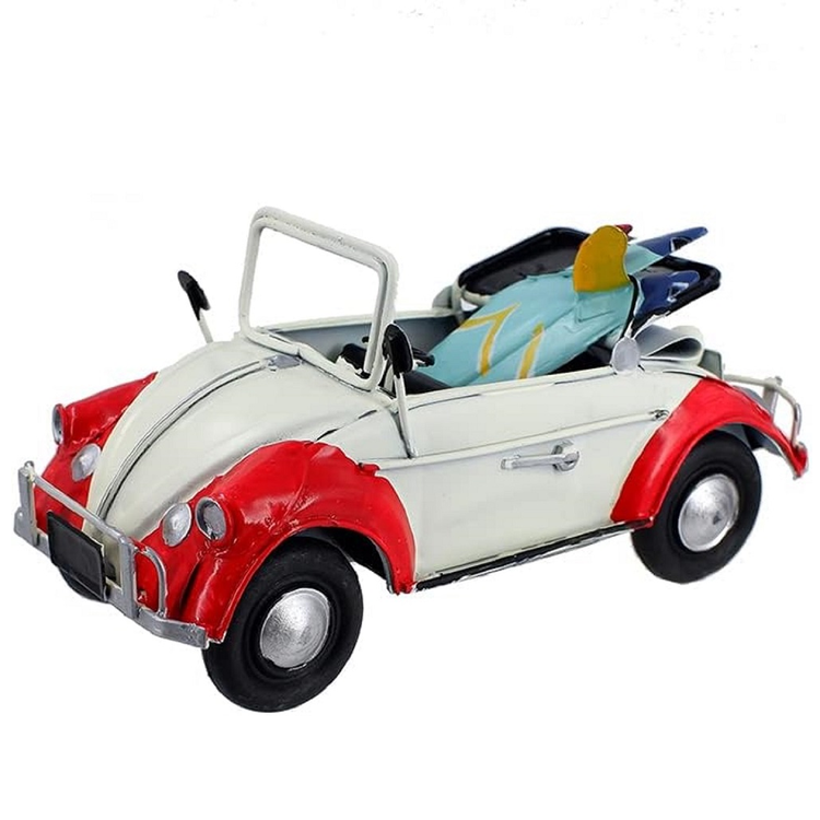 vintage inspired metal convertible car figurine in white and red, there is two blue and yellow surfboards in the back seat.