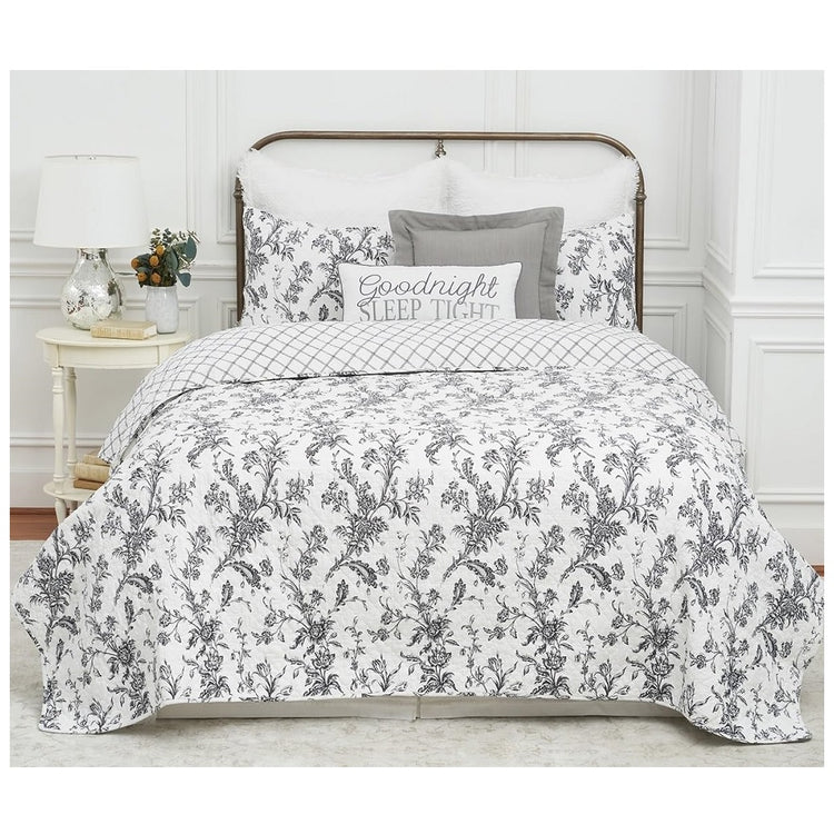 queen or full sized quilt set of a quilt and two pillow shams, white with a black floral design.