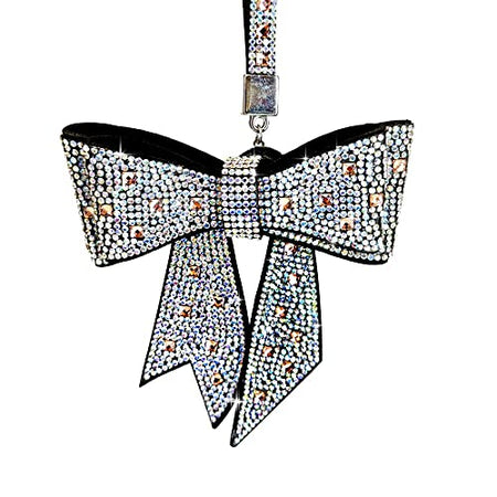 Bow hanging from a clip. The clip and the bow are covered in crystals with a rose gold color accent