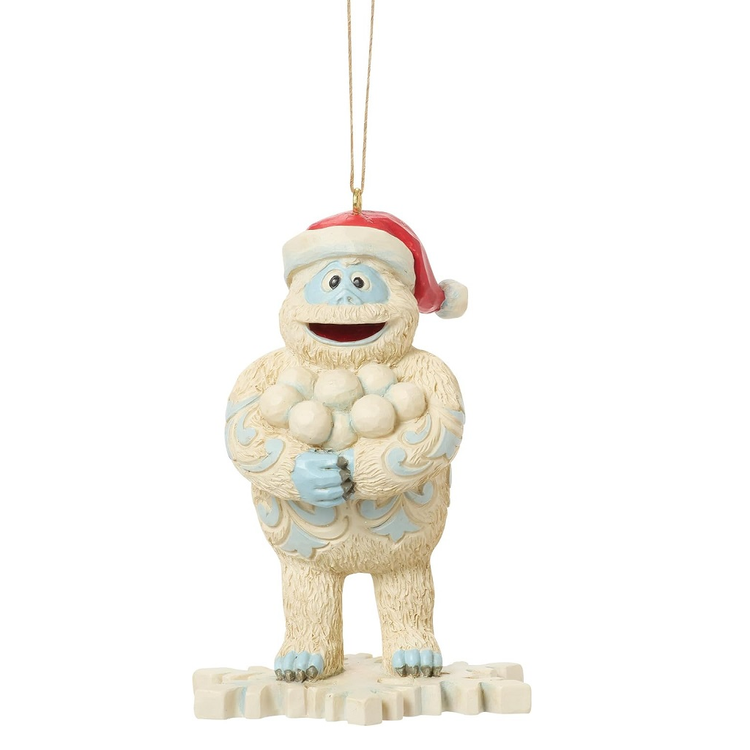 Resin ornament depicting Bumble the abominable snowman standing on a snowflake. He's wearing a santa hat and holding snowballs.