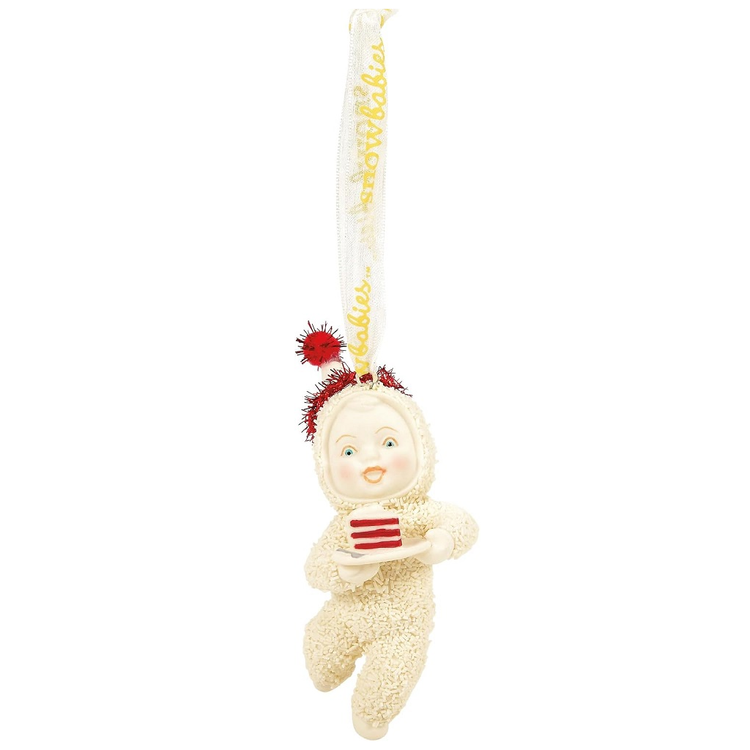 Decorative ornament of a baby in a snowsuit holding a slice of cake, hanging from a string.