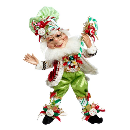 small bearded elf in green pants and chef hat, holding green and white candy cane.