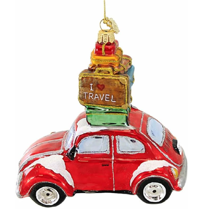 Blown glass red beetle style car with stack of luggage on top.