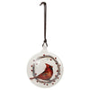 White round disc shaped ornament with a wreath and berries design and red cardinal sitting in the wreath