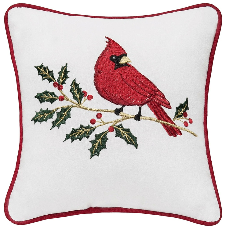 Decorative pillow with a red cardinal and holly design on a white background