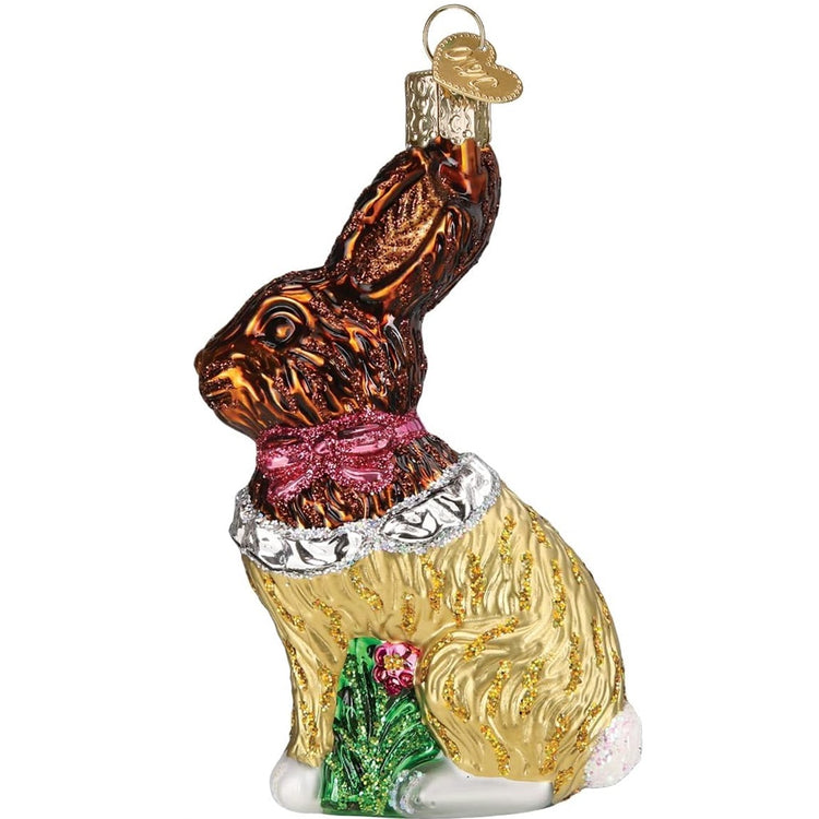 Ornament shaped as a chocolate Easter bunny.  Bunny wears a pink bow, appears to be wrapped in gold foil half unwrapped to see the head.