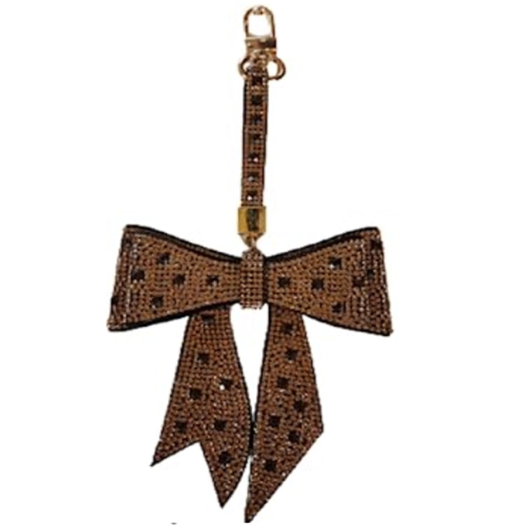 Bow that hangs from a short strap with a clip to hang on a purse as a charm. Encrusted in cystals in brown with black accents.