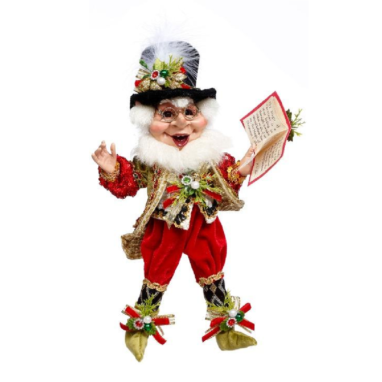 Decorative figurine of a bearded elf in festive attire with a book on a white background