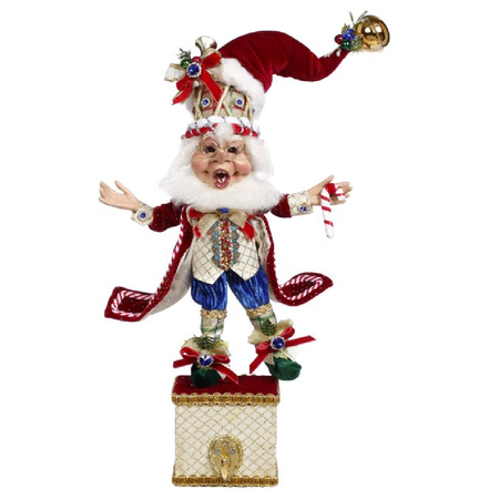 Bearded elf wearing red jacket, and santa hat with drum underneath, standing on box with hook for stocking.