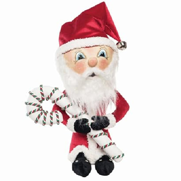 Santa figure wearing the traditional red suit and hat with a bell at the poing.  He holds a white candy cane with red and green stripes