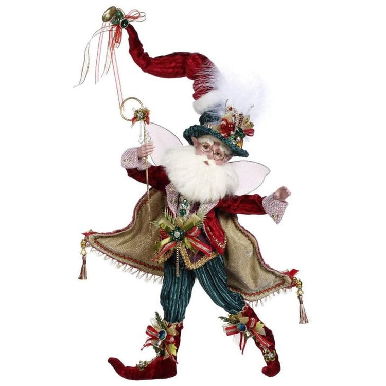 bearded fairy wearing red jacket with cape, green velvet pants and matching top hat, with red santa hat on top, he's holding a staff with crystals