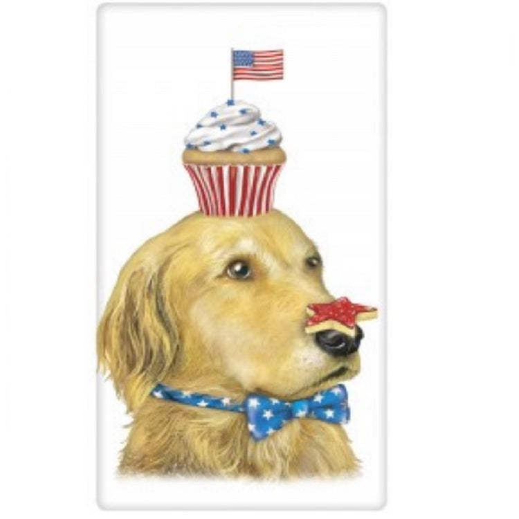 White kitchen towel featuring a golden retriever with a cupcake on his head with a flag in it. He also balances a star shaped cookie on his nose and wears a blue bowtie with white stars