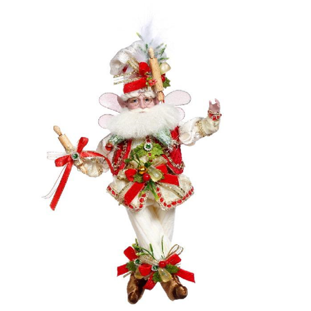 Decorative figure of a fairy in festive attire with red and gold elements on a white background