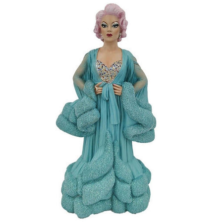 Drag queen ornament with light pink hair, a bedazzled corset top and a sheer teal robe with fur trim at the wrists and bottom.
