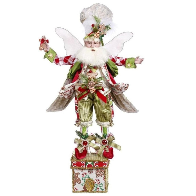 bearded fairy figurine with green outfit, a chefs had and cookie accents, standing on a box with a hook for a stocking.