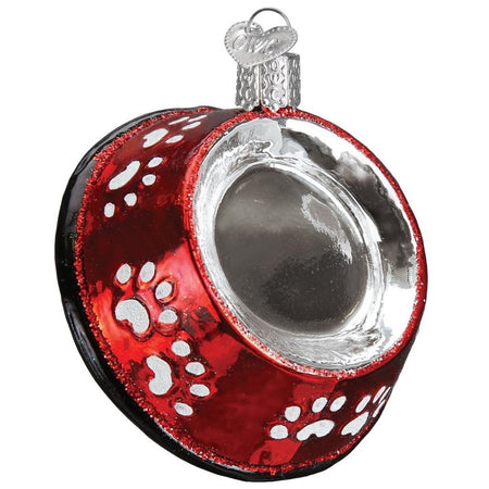 blown glass dog bowl ornament, red with white paw prints.