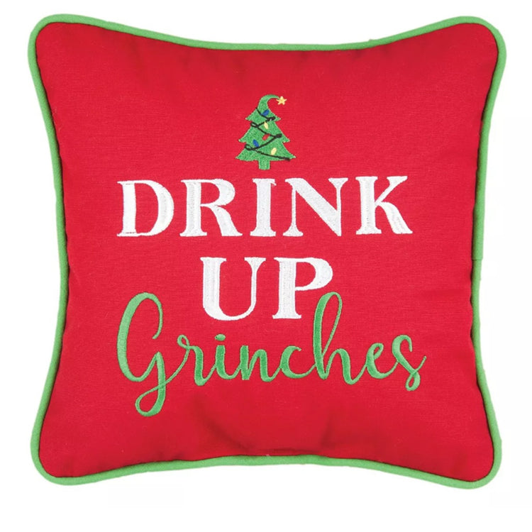 Red Christmas throw pillow with green piping and embroidered Drink Up Grinches text with tree accent