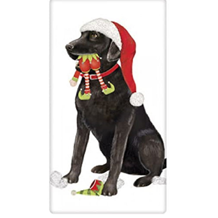 White kitchen towel with a black lab wearing a Santa hat with an elf toy in his mouth