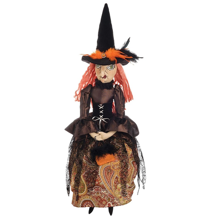 fabric witch figurine with orange yarn hair, a brown and black dress with brown paisley skirt.