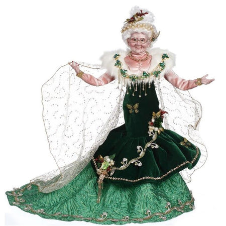 mrs. claus dressed in elegant emerald dress, with a fur shawl and gold glittered cape.