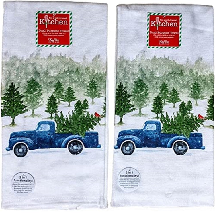 2 identical dish towels. White snow background of a Christmas tree farm and a blue pickup truck with a fresh cut tree in the back and a cardinal perched in the tree.