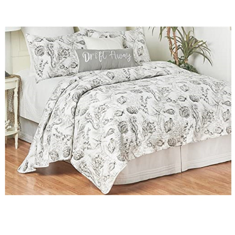 bed with quilt and shams. The matching pattern is grey with various shells, starfish and seahorse