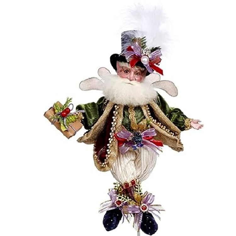 fairy wearing off white pants, green jacket and shirts hoding a package. He has a black top hat and booties. Lots of bows and beads.