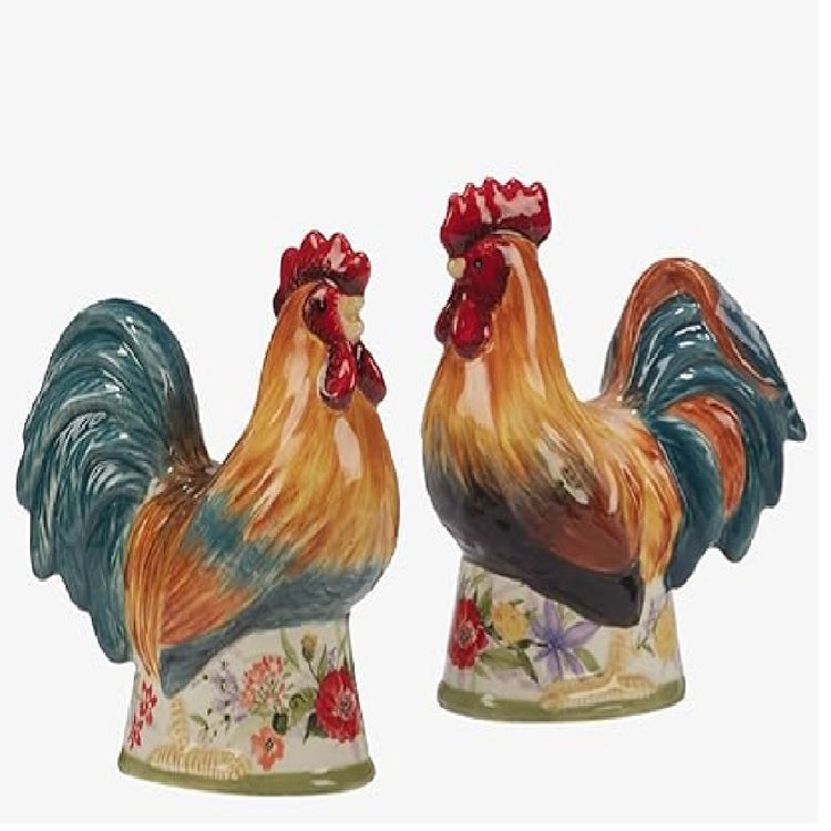 2 colorfull rooster shakers in shades of tan blue and red. They sit on an attached base with floral paint