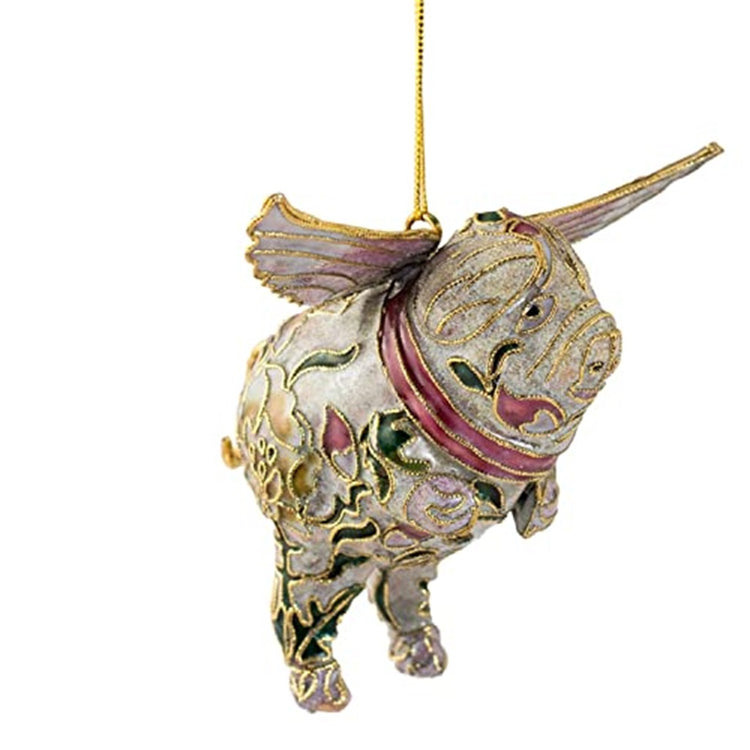 Ornament shaped like a flying pig with wings. White with floral textured enamel in pink and green. Gold filagree like embellishments all over