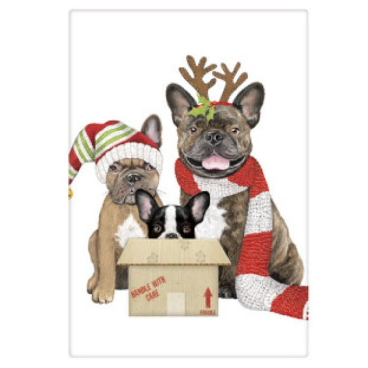 White kitchen towel with 3 French bulldogs dressed for Christmas. One has a red and white scarf and antler headband, another is in a mailing box and the 3rd wears a stocking cap.