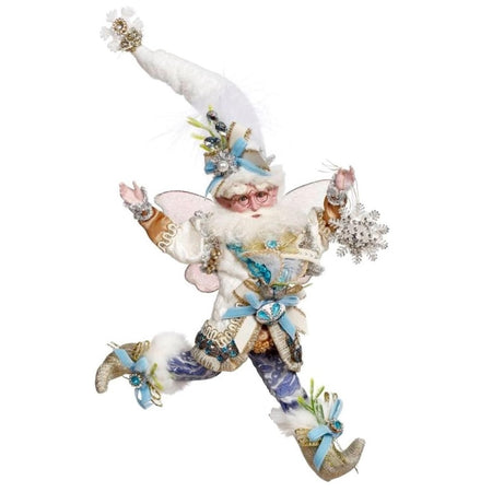 bearded fairy wearing white and gold jacket and stocking cap, blue swirl patterned pants, and holding a snowflake ornament