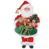 Standing Santa Figurine in traditional closes carrying a full green sack of presents, stuffed bears and nutcrackers with a tree.