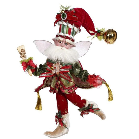 bearded fairy wearing red and green outfit and holding a spatula with gingerbread cookie.